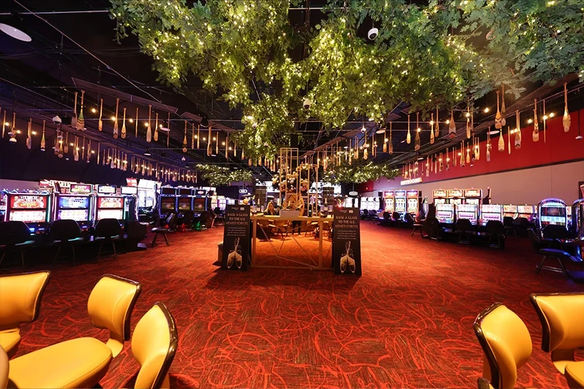 Gaming floor with carpet, gaming machines, and suspended tree decorations
