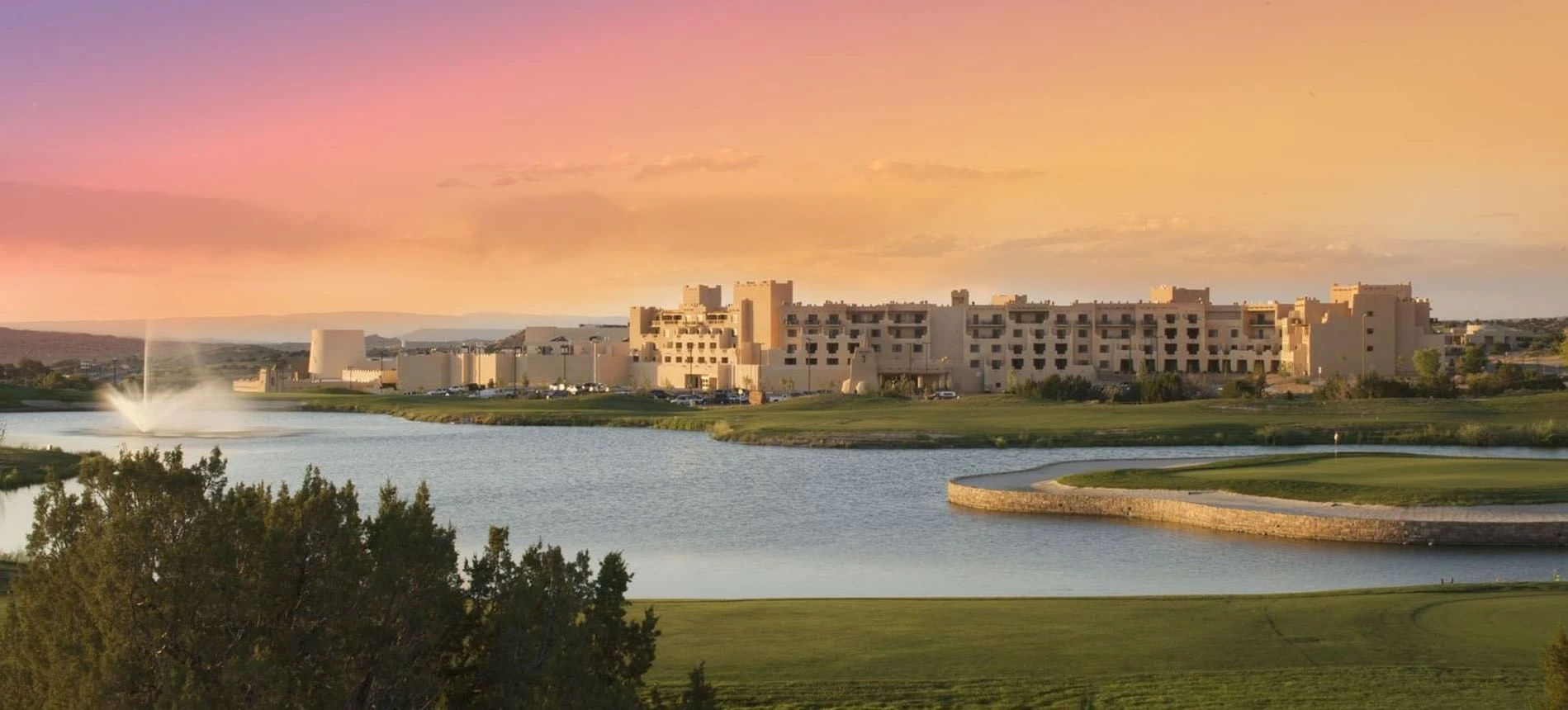 Hilton Santa Fe Buffalo Thunder exterior overlooking the pond at sunset