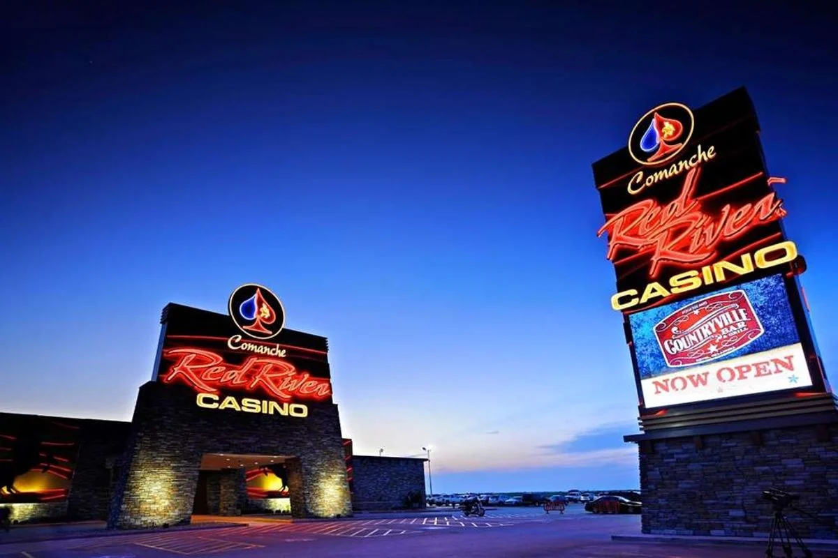 Comanche Red River Casino entrance and illuminated roadside sign at dusk