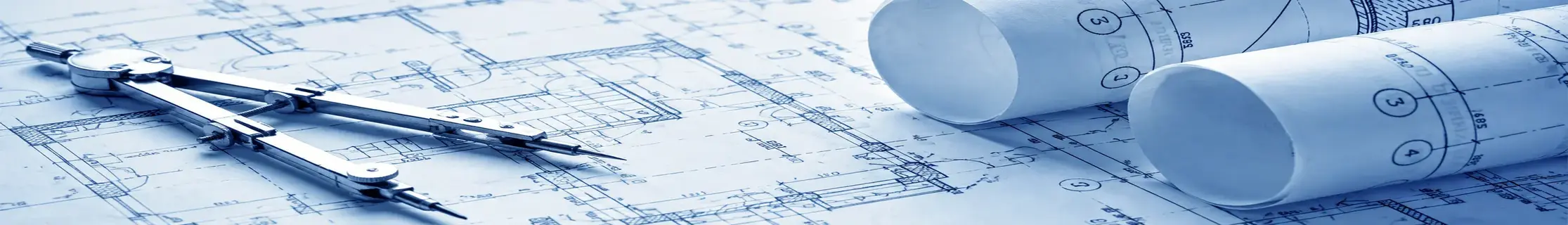 Rolled architectural blueprints and a drafting measuring tool