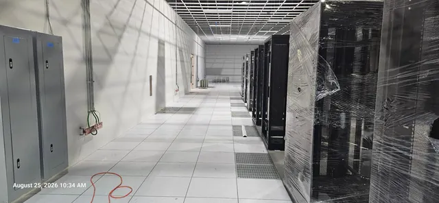 Raised floor aisle with airflow grates beside data center cabinets