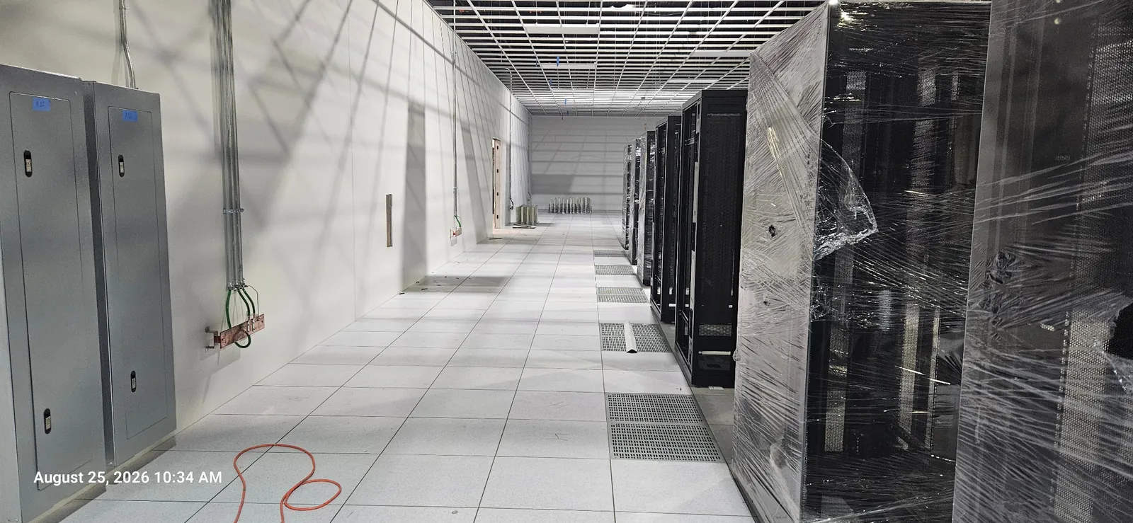 Raised floor aisle with airflow grates beside data center cabinets
